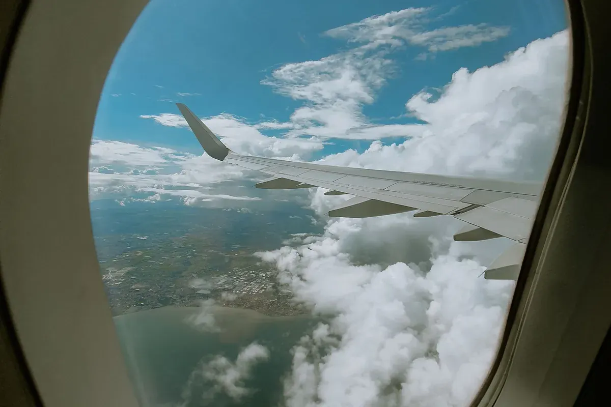 Vedere din hubloul avionului spre cer, în drum spre vacanță